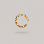 Gold and turquoise ear cuff on it's side on a light gray background