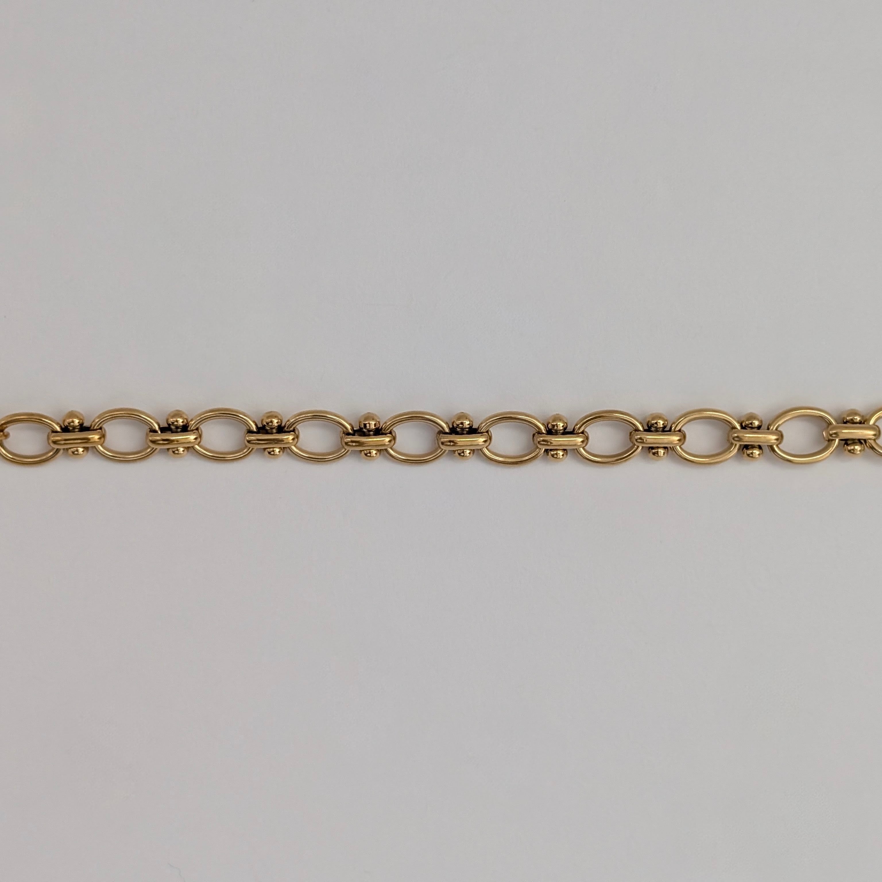 Gold chain  bracelet on a light gray background