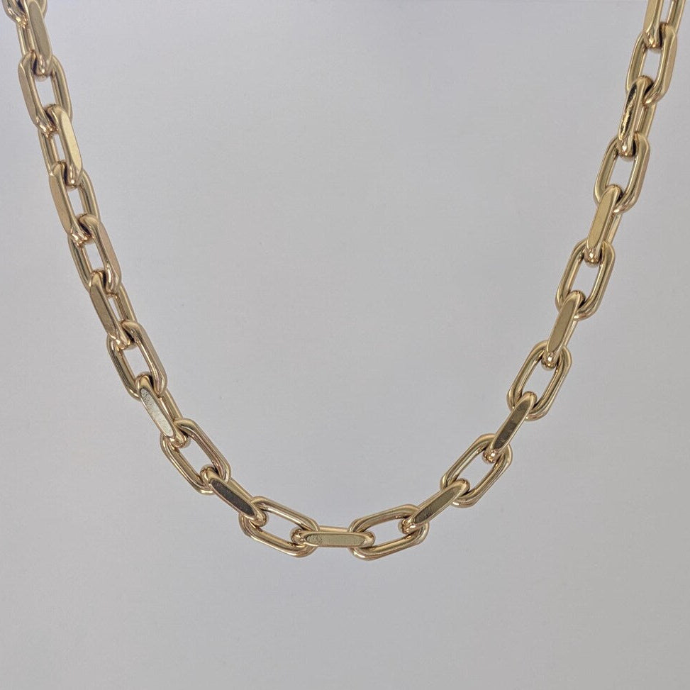Gold chain necklace on a light gray background