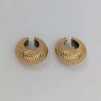 Pair of gold ear cuff on a light gray background