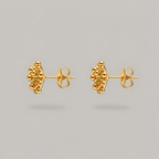 A pair of gold stud earrings with a textured, clustered organic design, shown from the side on a neutral gray background.