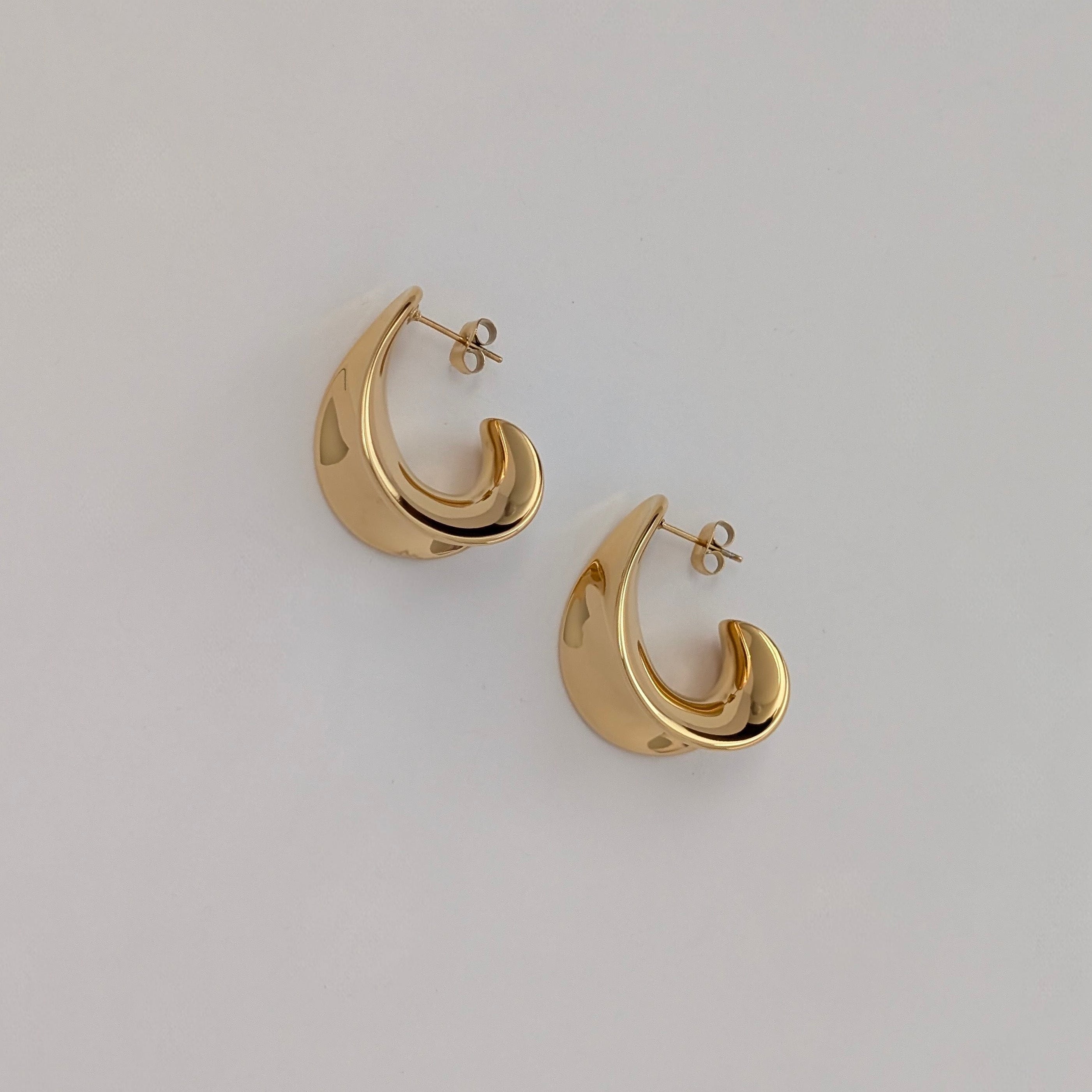 Pair of gold hoop earrings on a light gray background