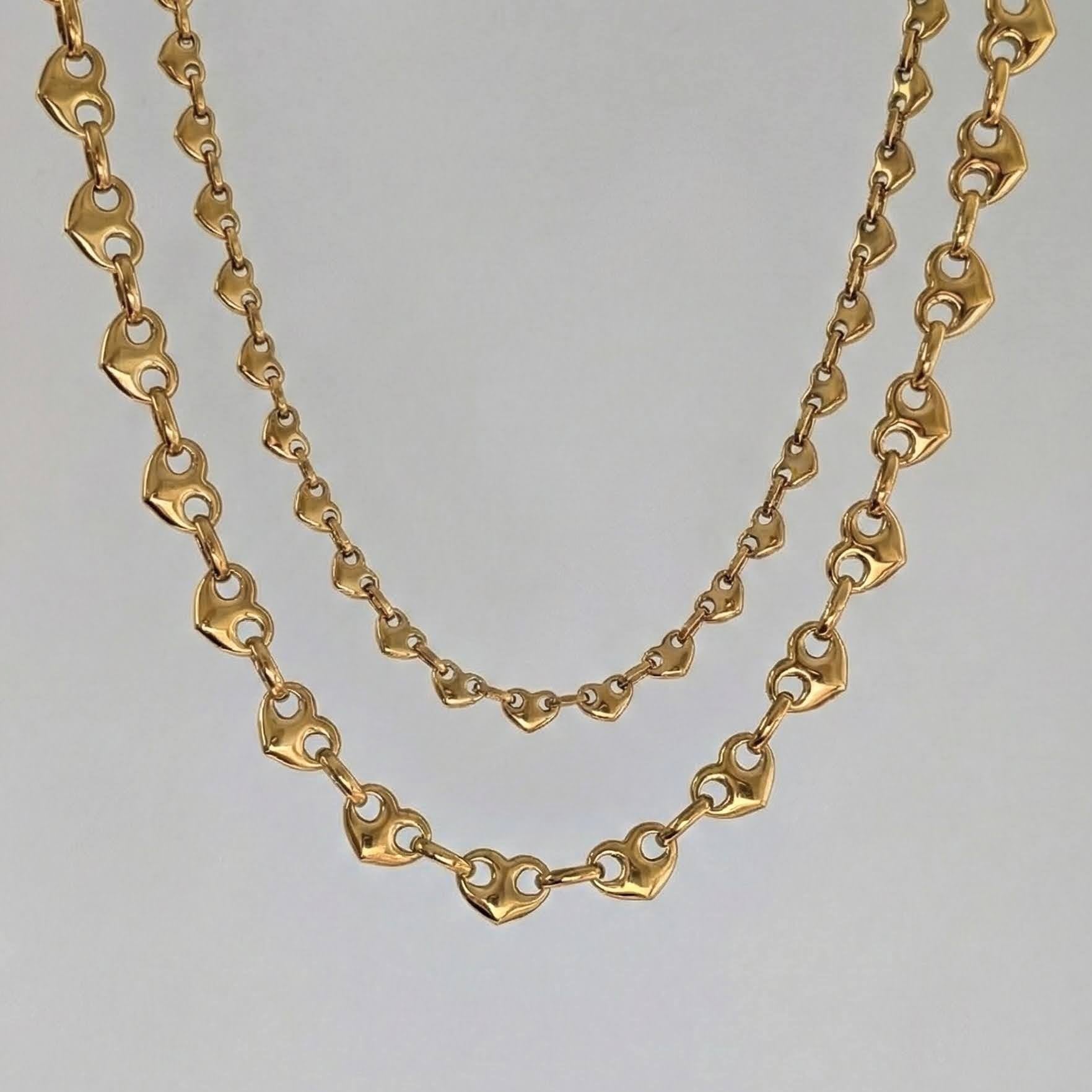 Gold chain necklace on a light gray background