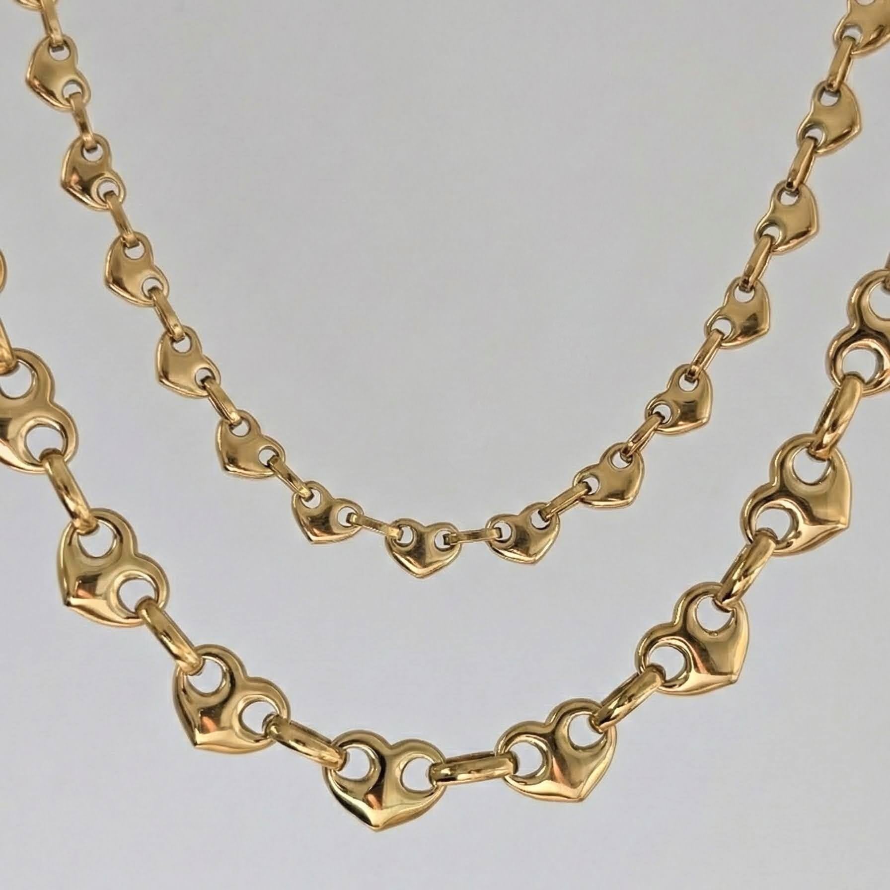 Gold chain necklace on a light gray background