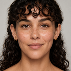 Close-up of a woman with curly hair against a neutral background