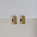 Gold rectangular earrings on a white background