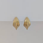 Pair of gold earrings on a light gray background