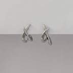 Pair of silver earrings on a gray background