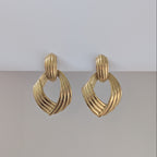 Pair of gold earrings on a light gray background