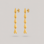 Gold earrings on a light gray background