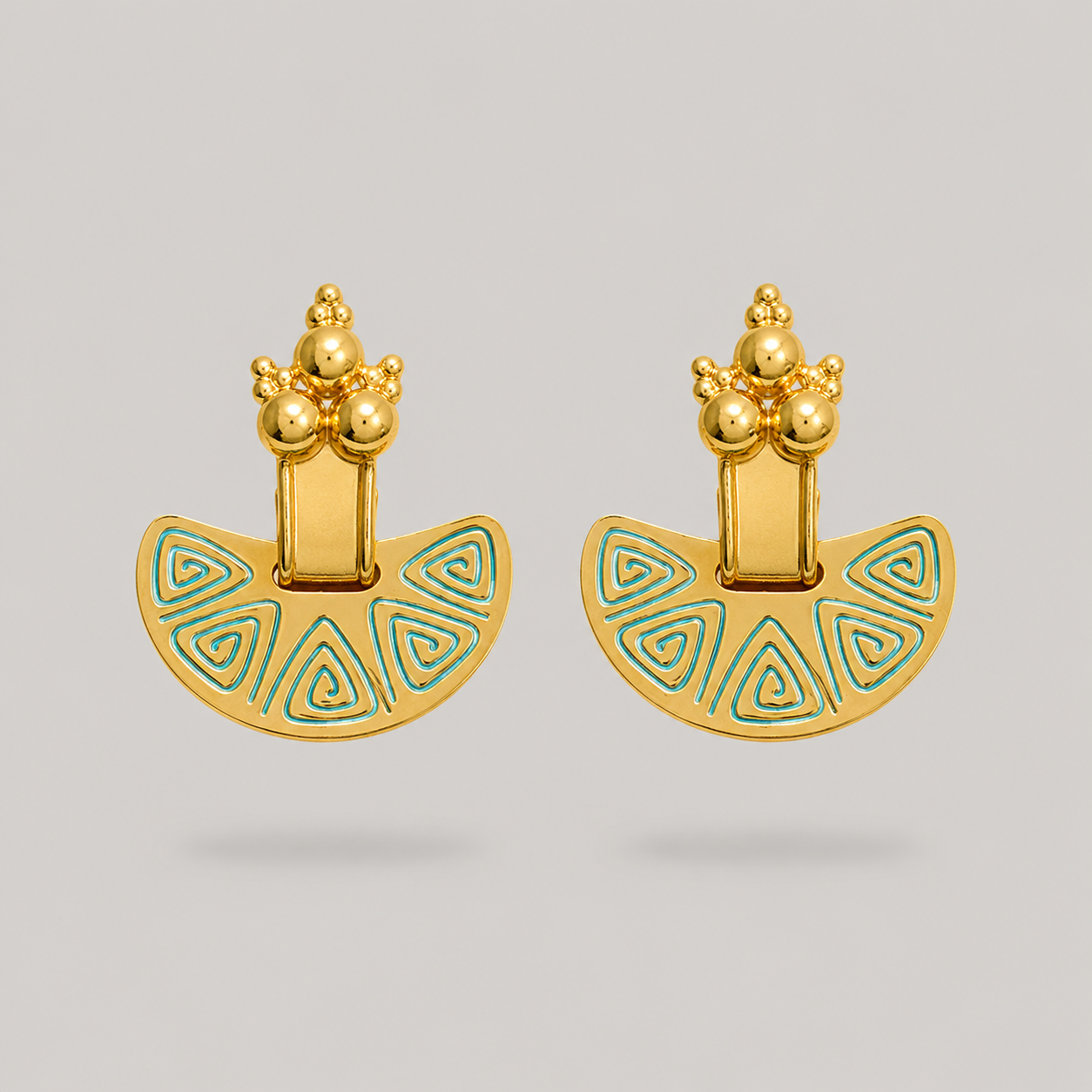 Pair of gold earrings with blue enameled designs on a light gray background