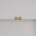 Gold earring on white background.