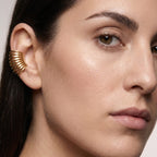 Close-up of a woman's face wearing a gold earring.