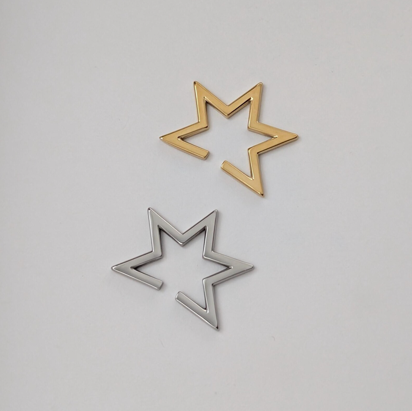 Gold and silver star-shaped Ear Cuffs on a white background.