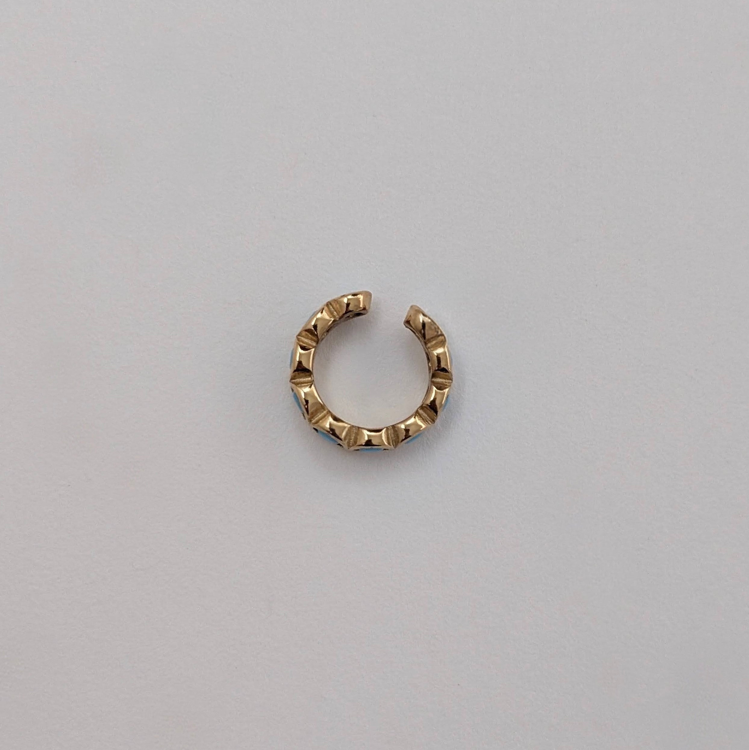 Gold Cuff earring on a light gray background