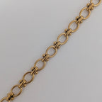 Gold chain bracelet on a light gray background