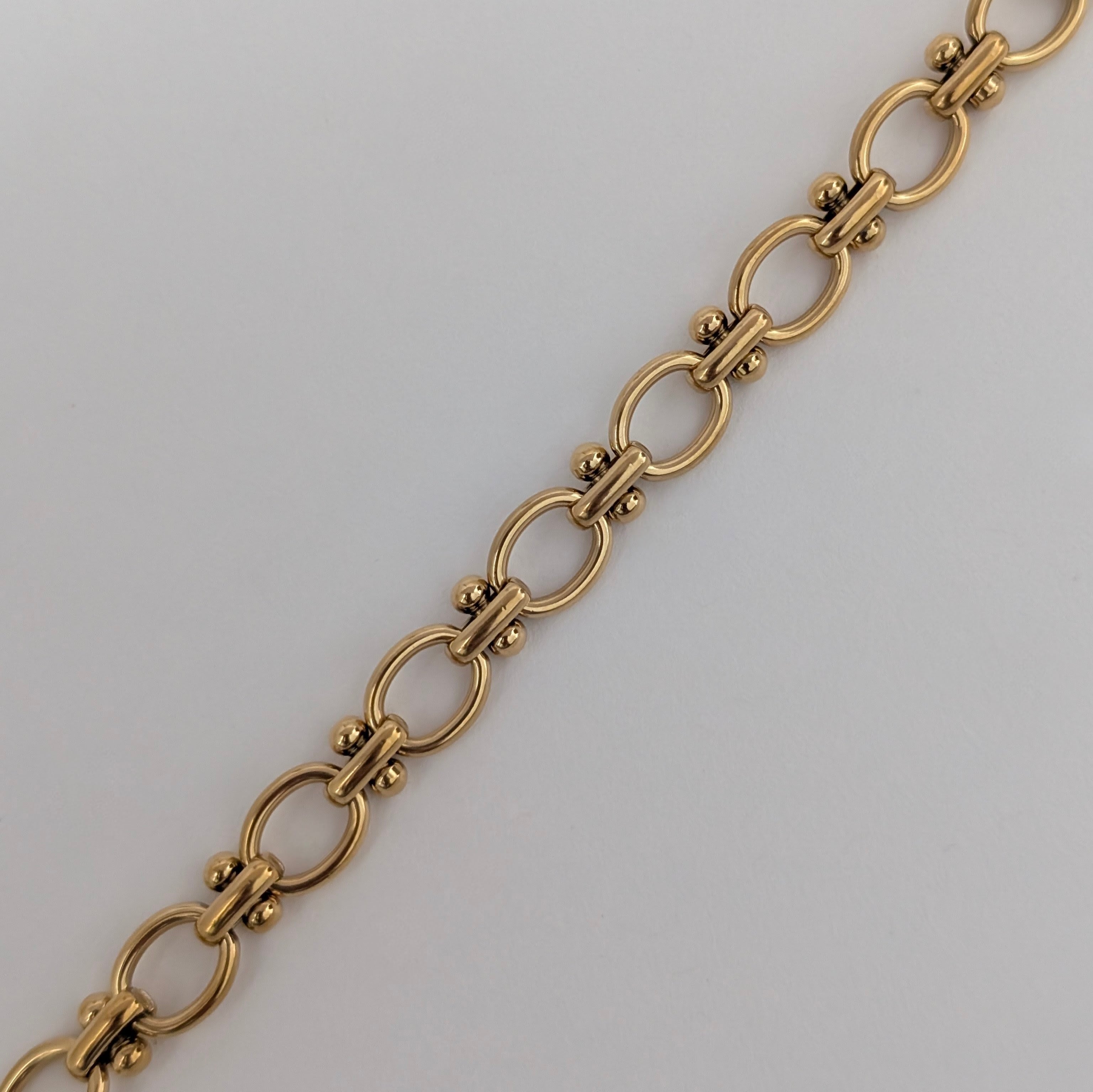 Gold chain bracelet on a light gray background