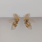 Pair of gold butterfly earrings on a light gray background