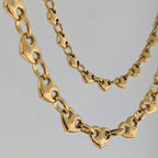 Gold chain necklace on a gray background
