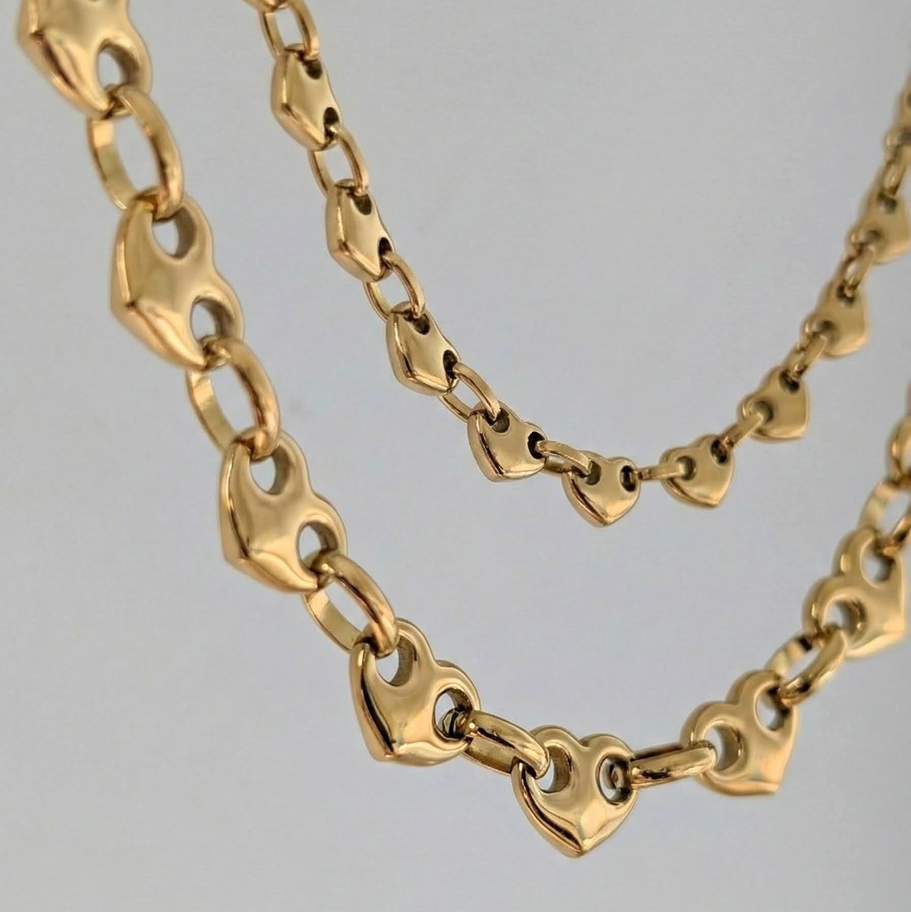 Gold chain necklace on a gray background
