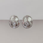 Pair of silver earrings on a light gray background