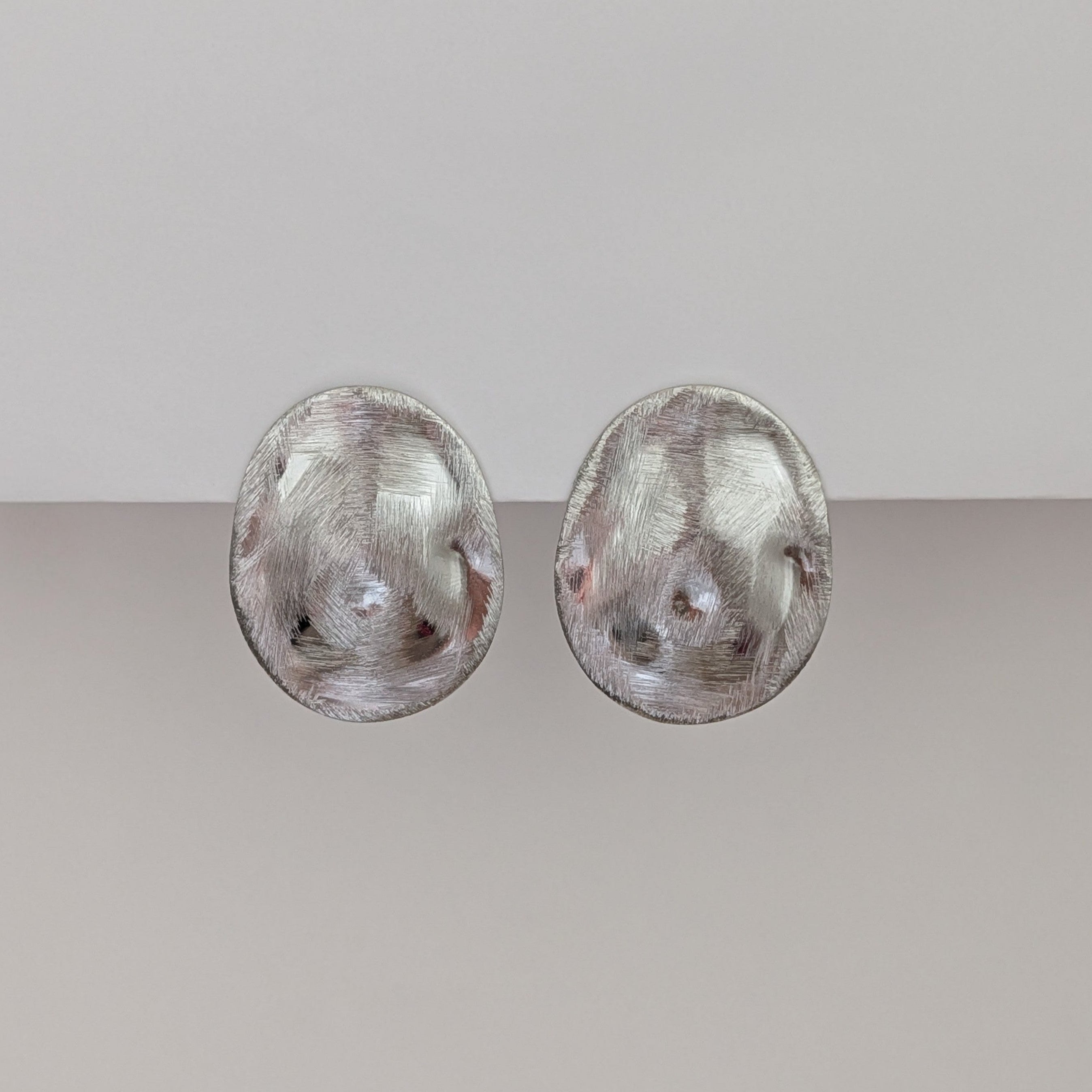 Pair of silver earrings on a light gray background