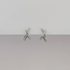 Pair of silver earrings on a gray background