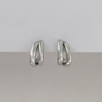 Pair of silver hoop earrings on a light gray background