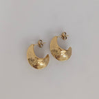 Gold hoop earrings on a light gray background