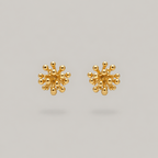 A pair of gold stud earrings with a textured, spherical cluster design resembling small metallic beads radiating from a central point, shown on a solid light gray background.
