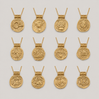 Gold necklaces with coin pendants on a light gray background