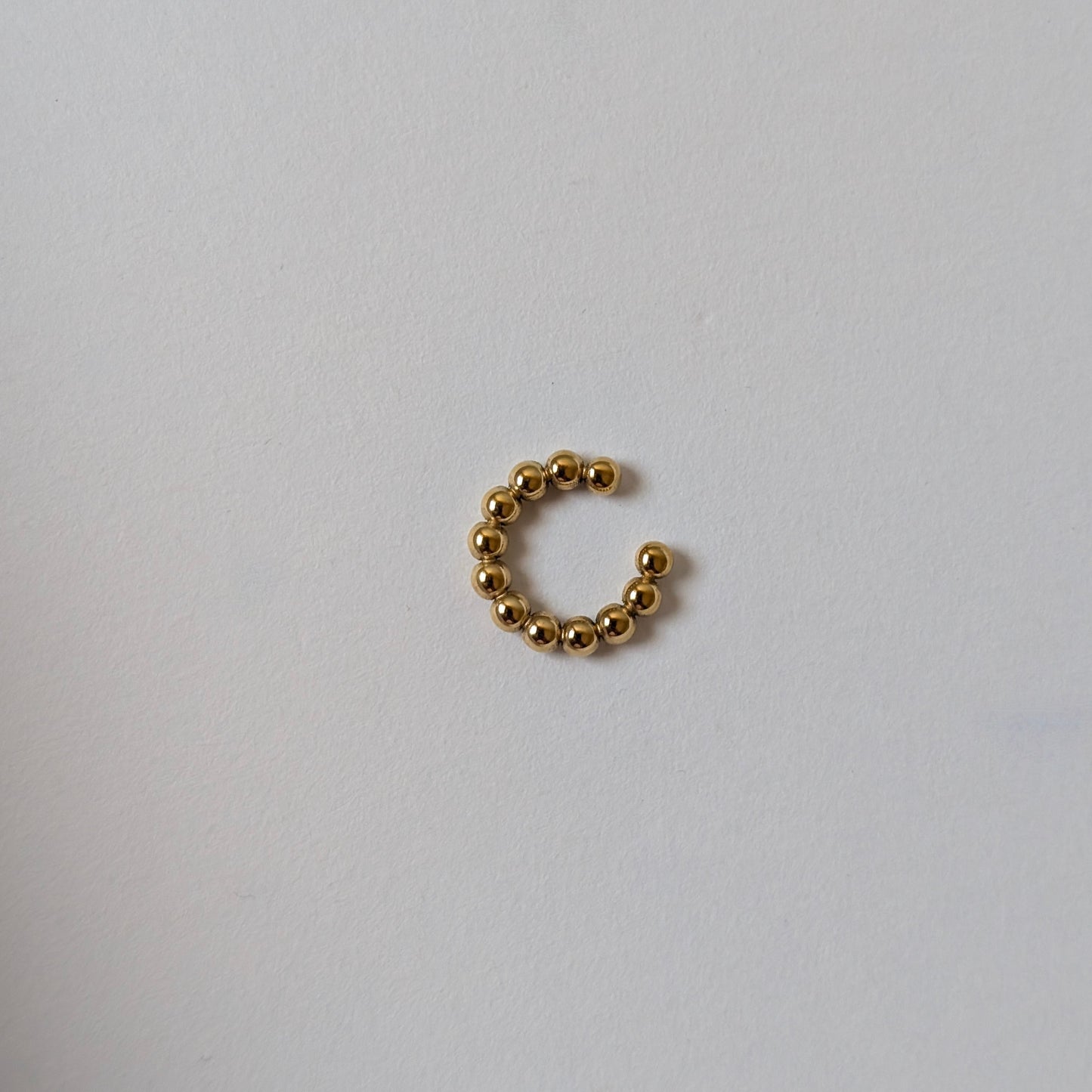 Side angle of mini ear cuff highlighting opening for easy fit and hypoallergenic steel base.