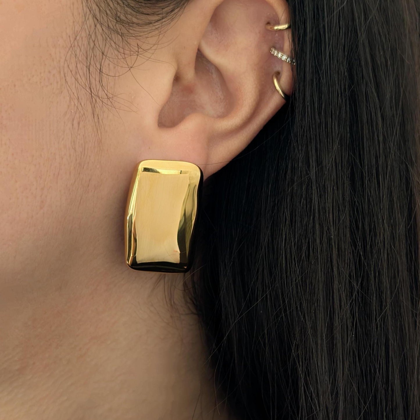 Stacked ear look featuring two gold chunky rectangle stud earrings layered together for a bold geometric statement.