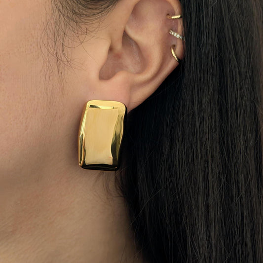 Stacked ear look featuring two gold chunky rectangle stud earrings layered together for a bold geometric statement.