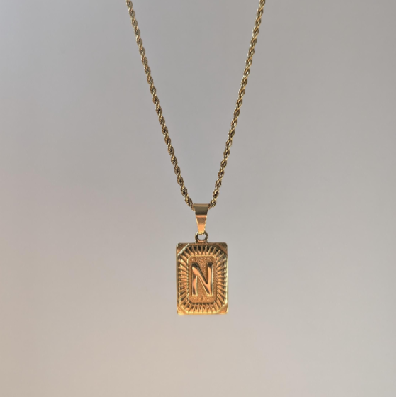Third front angle of gold medallion letter necklace showing detailed beaded border around personalized 18k‑plated initial pendant.