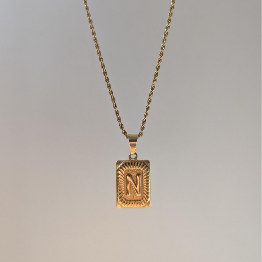 Third front angle of gold medallion letter necklace showing detailed beaded border around personalized 18k‑plated initial pendant.