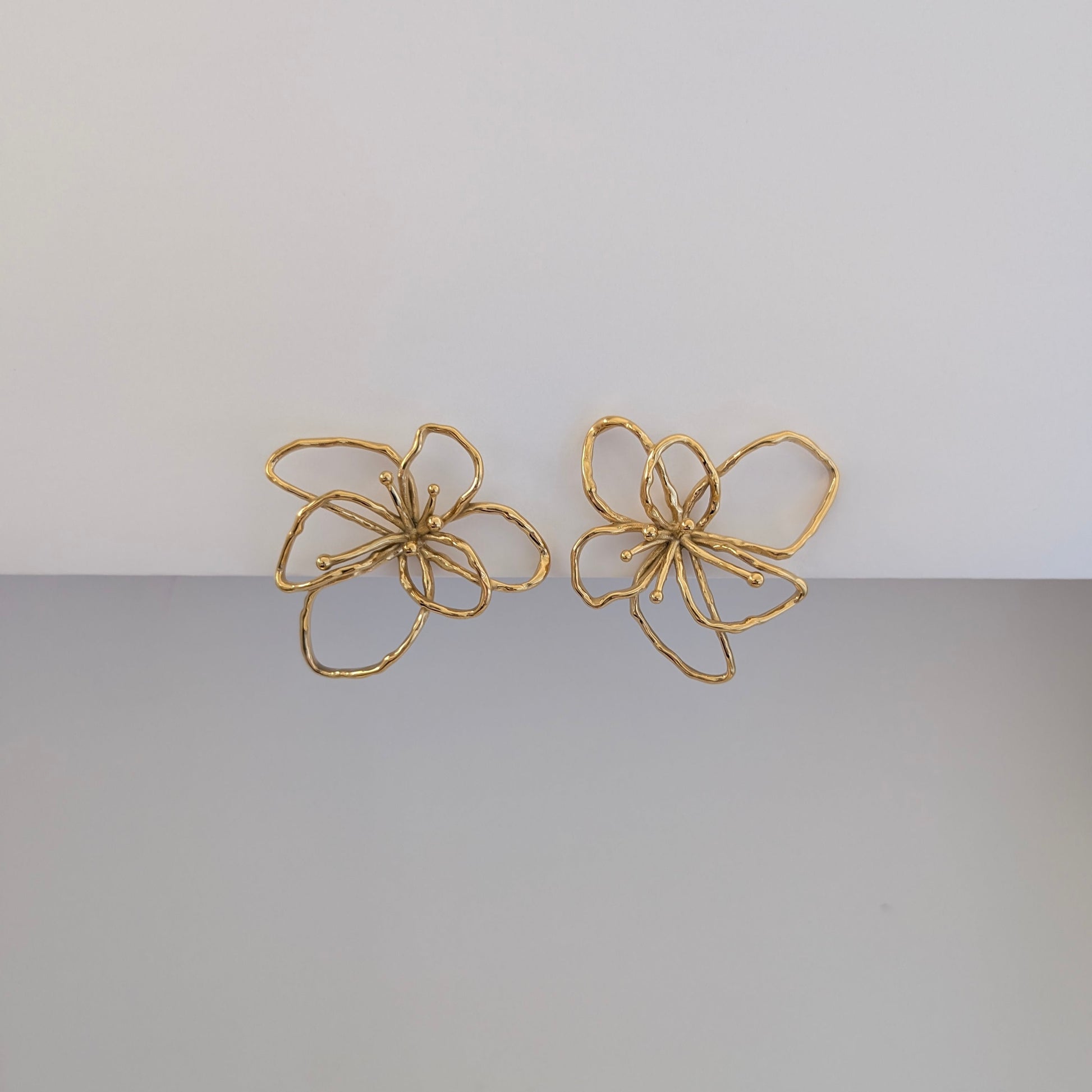 Alternate front angle highlighting textured orchid petals on gold statement earrings, lightweight 12.9 g pair