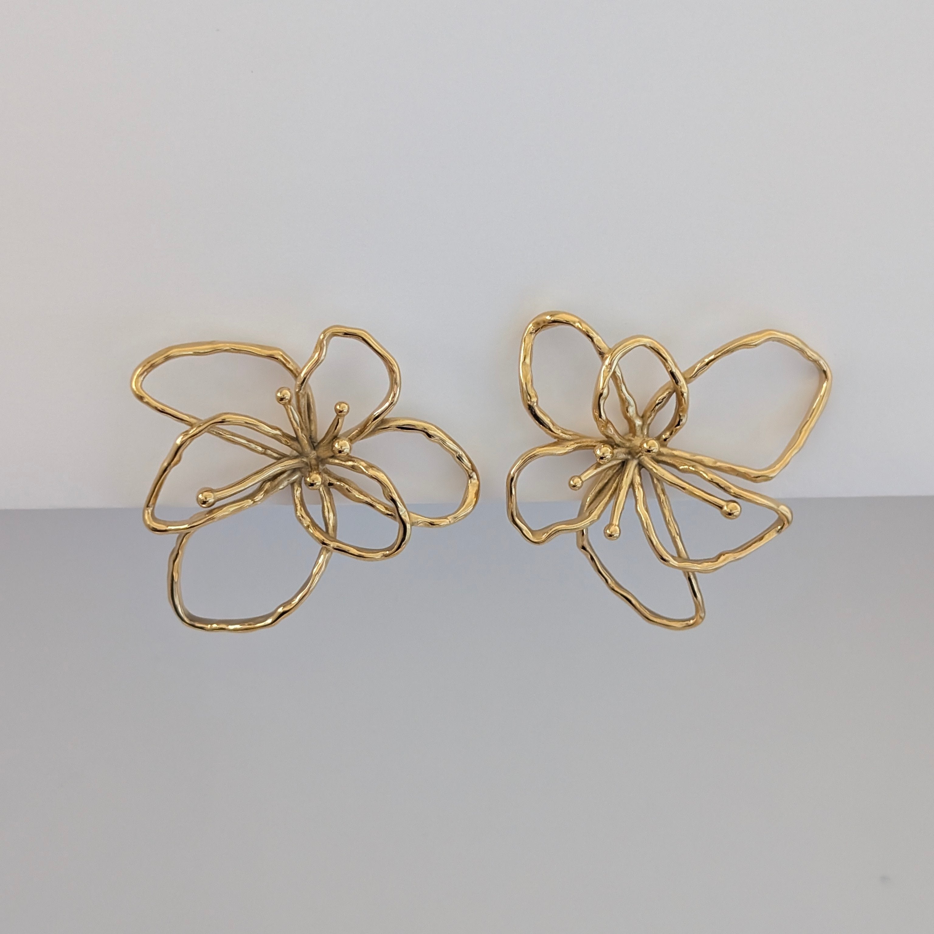 Front view of gold orchid statement earrings—18k plated, 4 × 4.21 cm sculptural floral studs.