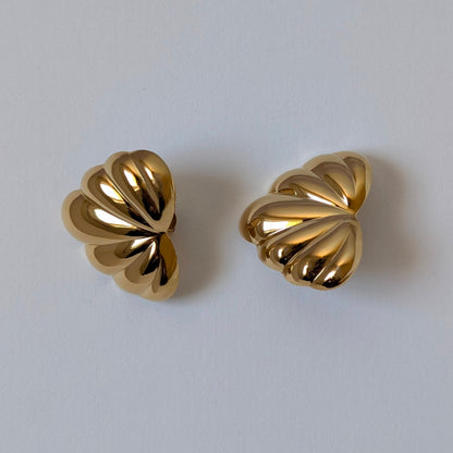Flat‑lay of Amore gold palm leaf earrings, waterproof PVD coating, tarnish resistant.