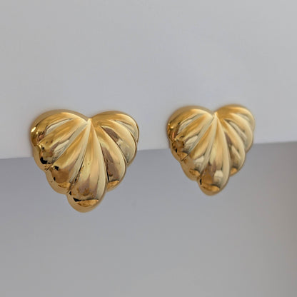 Side angle showing sculpted palm leaves and 2.6 × 3 cm size on gold statement earrings.