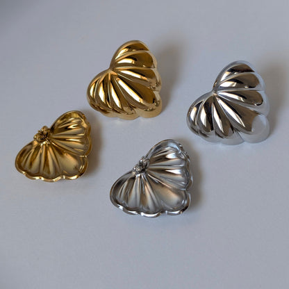 Gold and silver palm leaf statement earrings side‑by‑side—Amore collection, 18k gold‑plated and stainless‑steel.