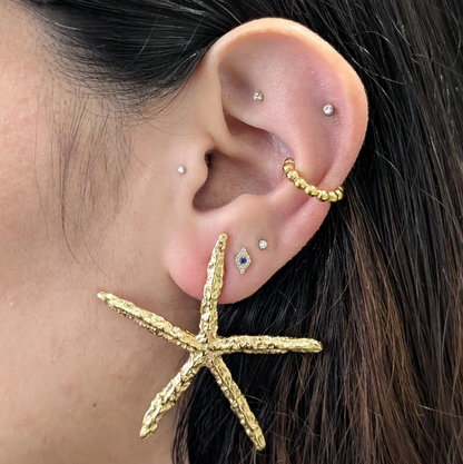 Styled stack featuring starfish statement earrings for a vacation‑ready look.
