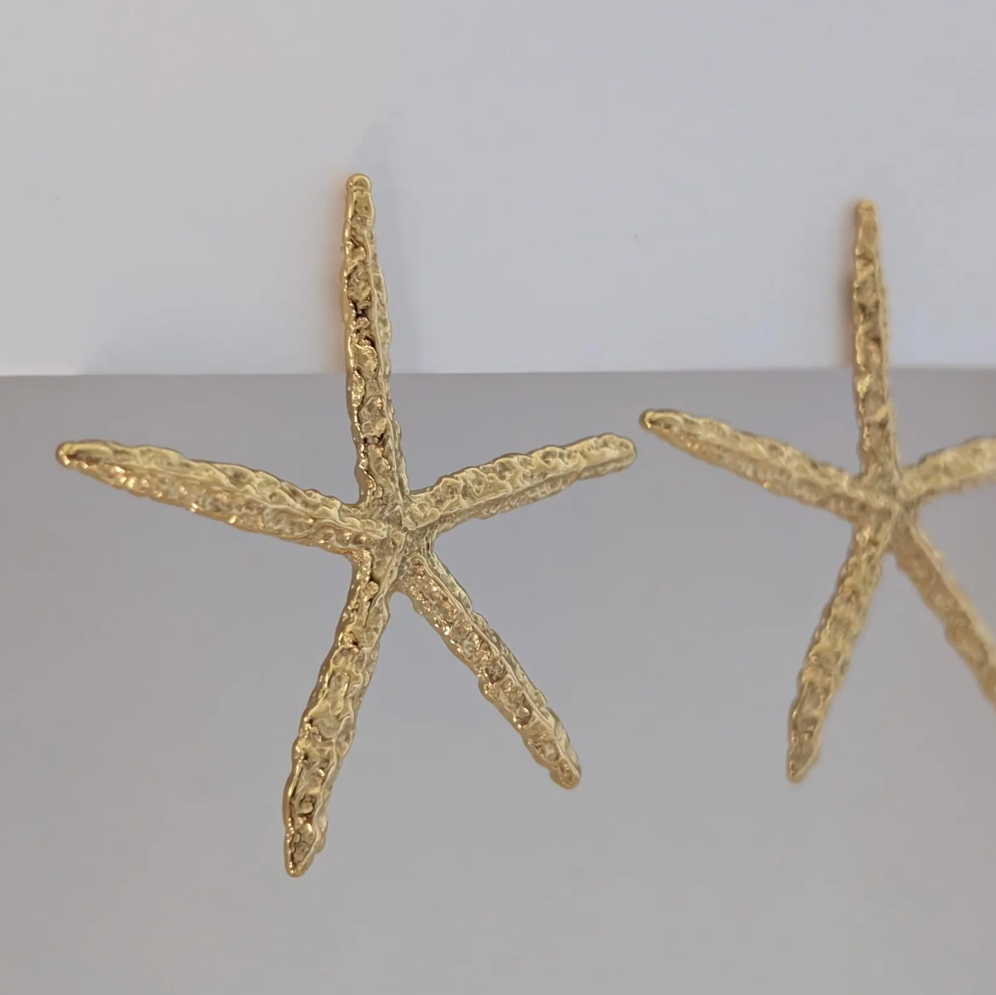 Side angle showing sculpted starfish detail and 3.3 × 5.4 cm size of gold statement earrings.