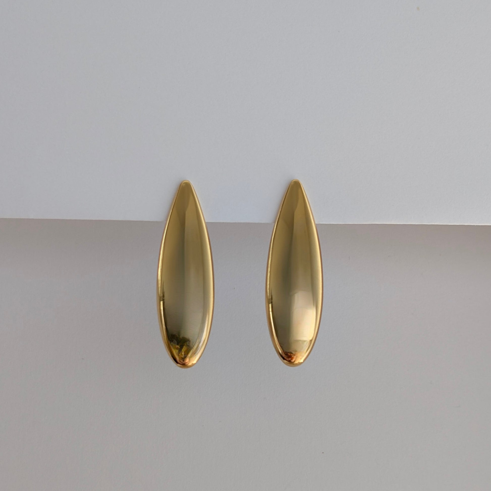 Front view of gold teardrop statement earrings—sleek high‑shine finish, 18k plated. 