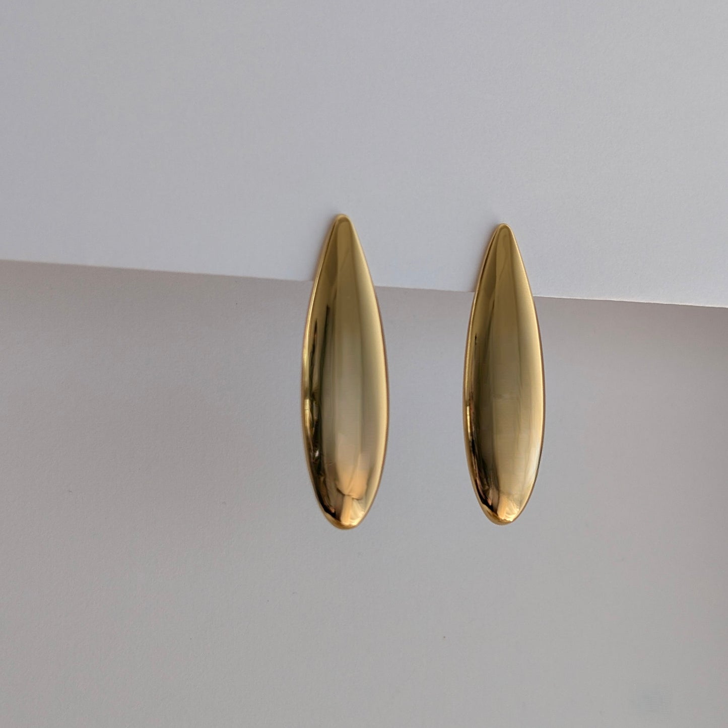 Side angle showing elongated 1.42 × 4.53 cm teardrop profile on lightweight gold earrings.