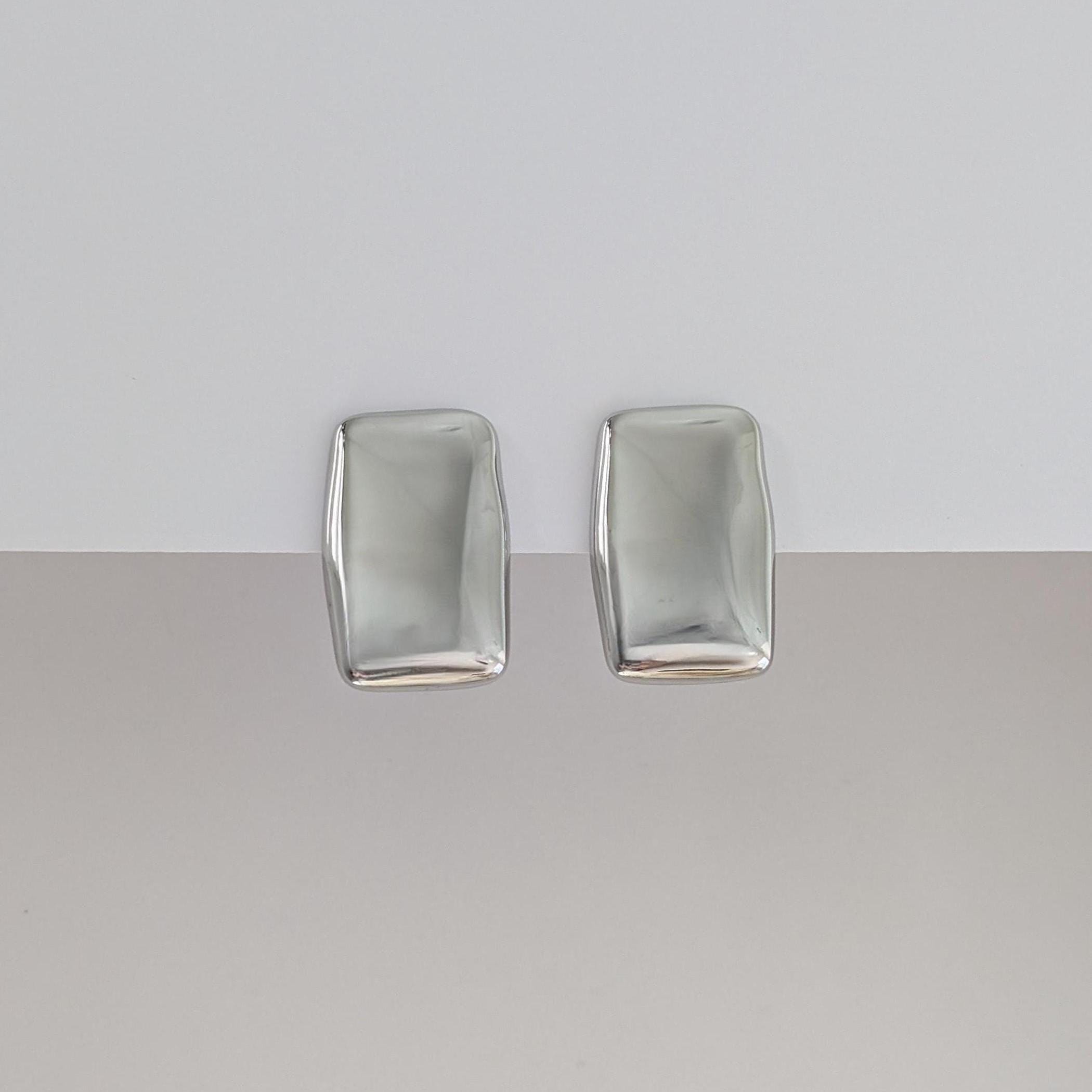 Front view of silver chunky rectangle stud earrings—polished stainless steel, 1.98 × 3.07 cm.