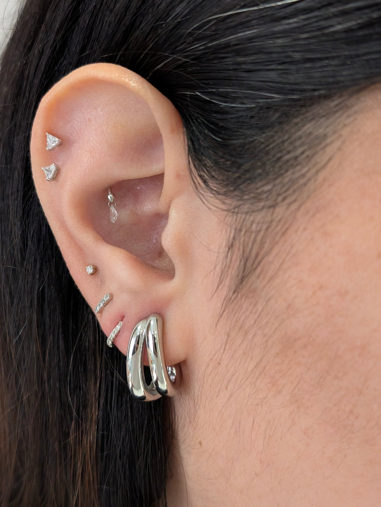 Side on‑ear angle highlighting sleek silver mini double hoops, waterproof and tarnish‑resistant for daily wear.