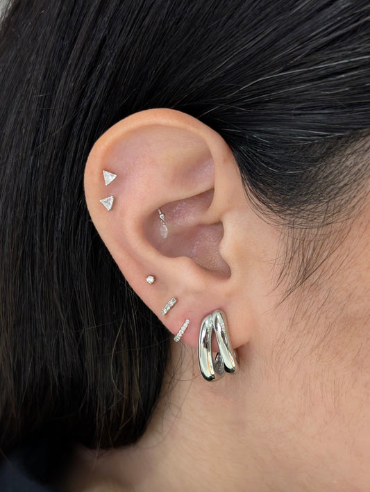 Close‑up of silver mini double hoop earrings worn—stacked look without extra piercing, hypoallergenic stainless steel.