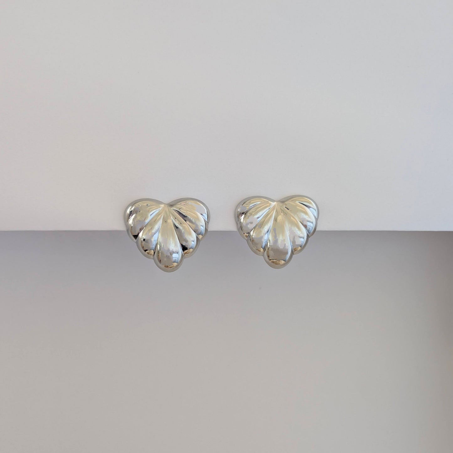 Front view of silver palm leaf statement earrings—316L steel base, hypoallergenic and tarnish resistant.