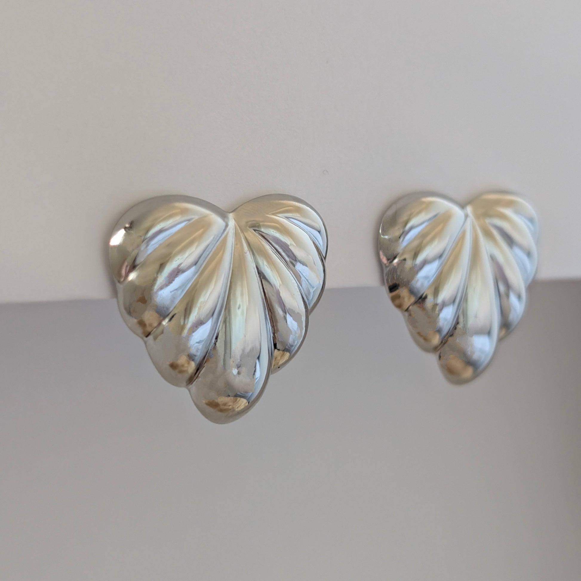 Side angle highlighting 3 cm tall silver palm leaf earrings’ sculpted leaves and polished shine.